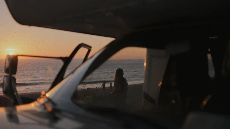 Women by beach through window of an RV