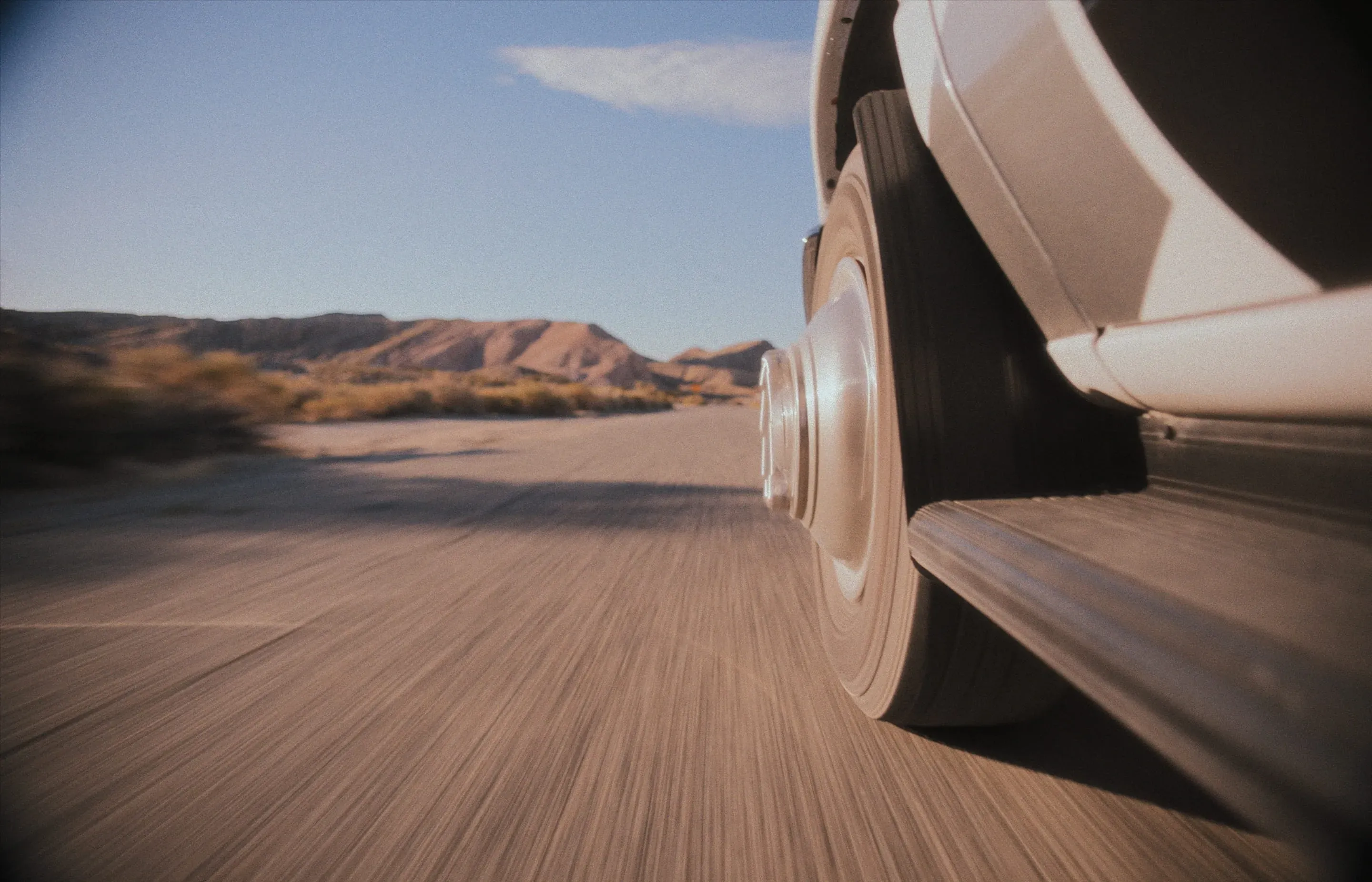 An image of a far away trailer driving down a tree-lined highway