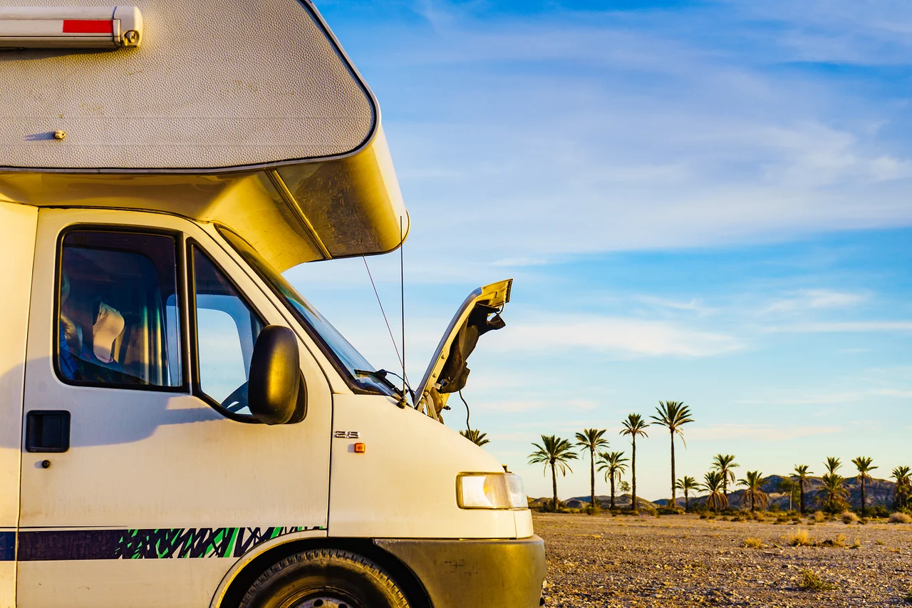 Camper van parked with the hood open.