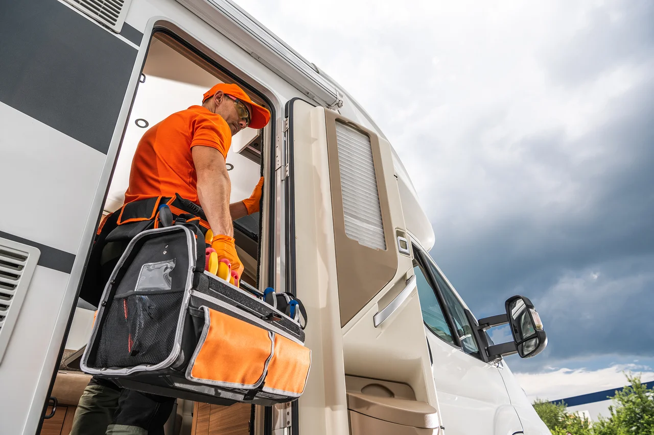 Worker stepping into a service van carrying a tool bag.