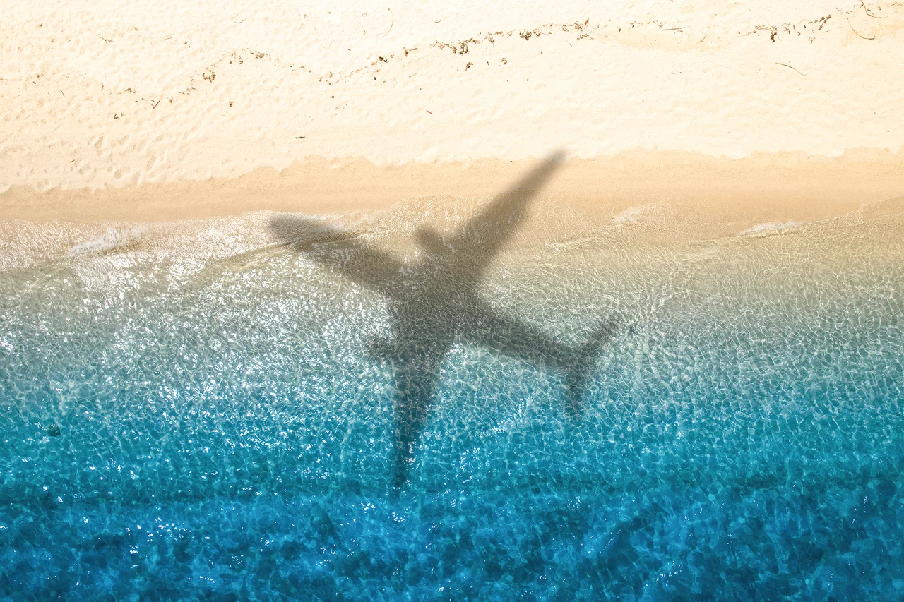 Airplane flying across a beach