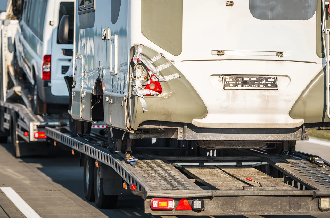 Travel trailer loaded on a transport trailer.