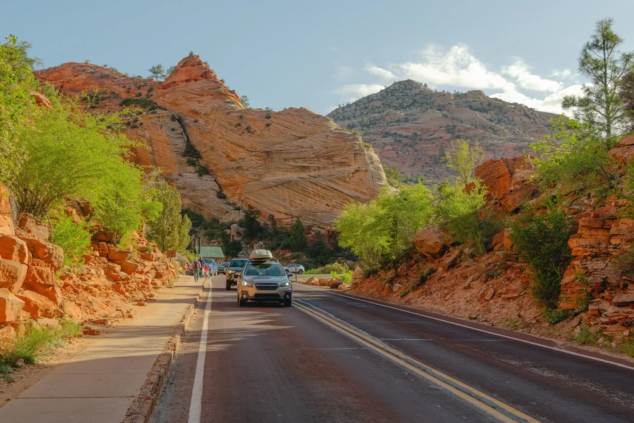 Traffic on the Zion–Mount Carmel road winding through red rock canyon scenery